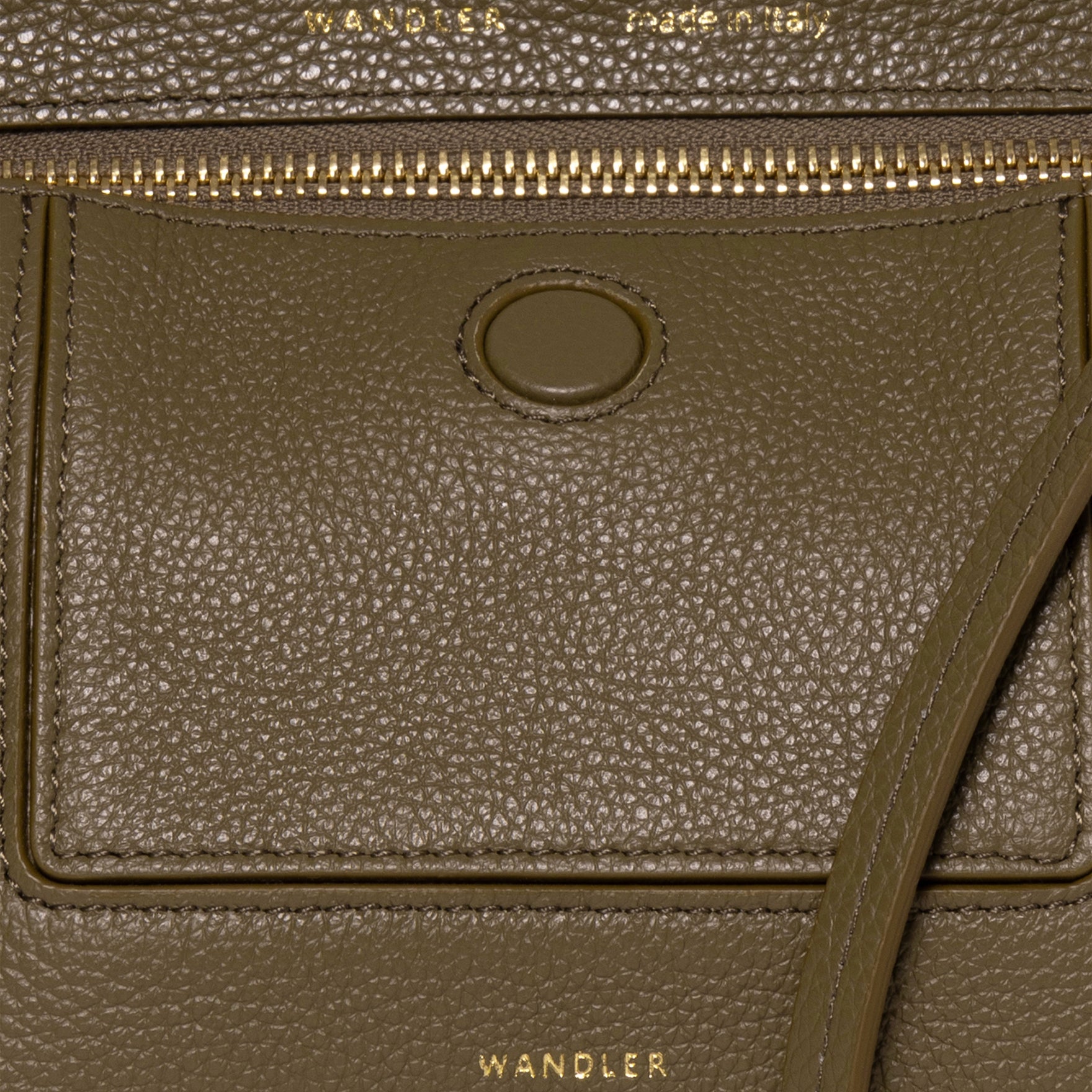 Wandler Penelope Slouch Mini in Olive Crust, green, Italian calf leather with golden hardware and slim adjustable strap, close up shot highlighting the leather and Wandler Logo.