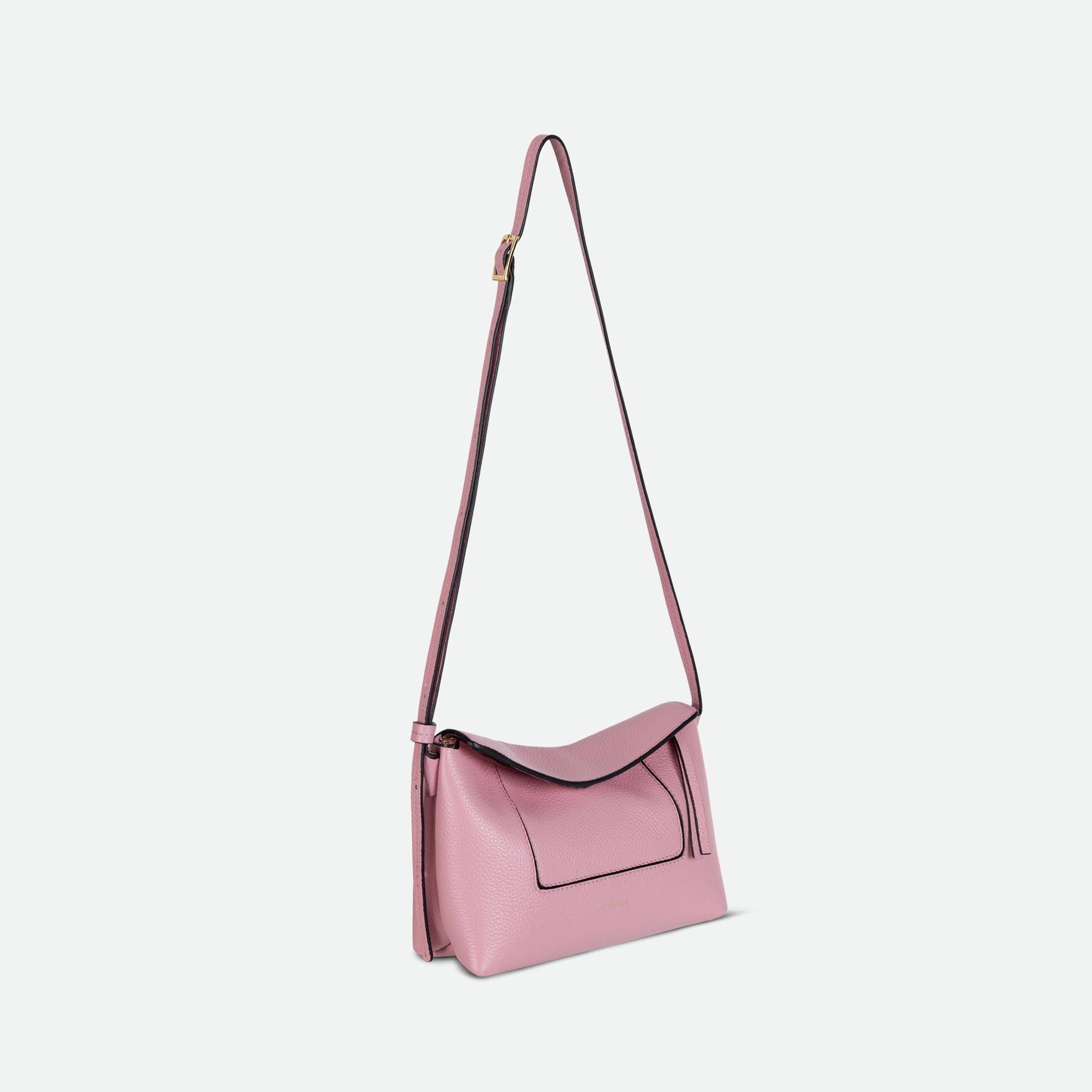 Wandler Penelope Slouch Mini in Rose Crust, pink, Italian calf leather with golden hardware and slim adjustable strap, pictured on model worn on the shoulder. The bag is pictured from a three quarters angle with the crossbody strap suspended in the air. 