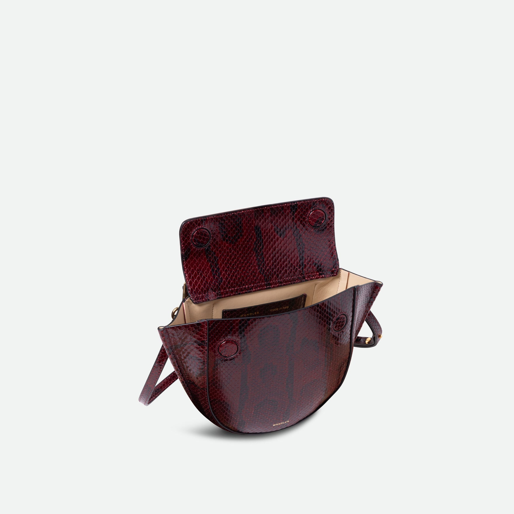 Wandler Hortensia Bag Mini in the color Bordeaux Python, deep dark red with python print, Italian calf leather with golden hardware, rounded silhouette and top handle. The bag is pictured from the front with the flap open, giving a slight view of the inside of the bag.