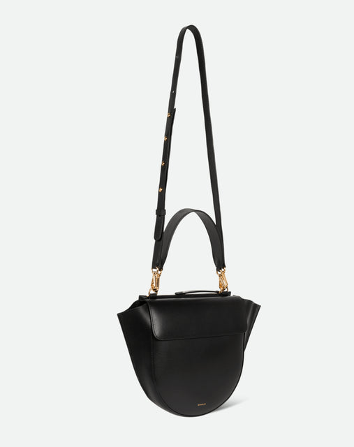 Wandler Hortensia Bag Medium in the color Black, made from Italian calf leather with golden hardware, rounded silhouette and top handle, pictured from three quarters angle with the straps suspended into the air. 