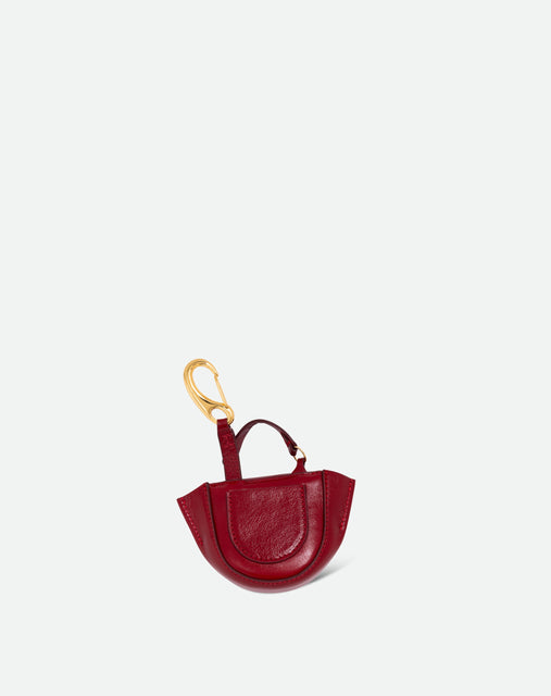 Wandler Hortensia Micro in cranberry calf leather with golden hardware, shown as a bag charm, backside view.
