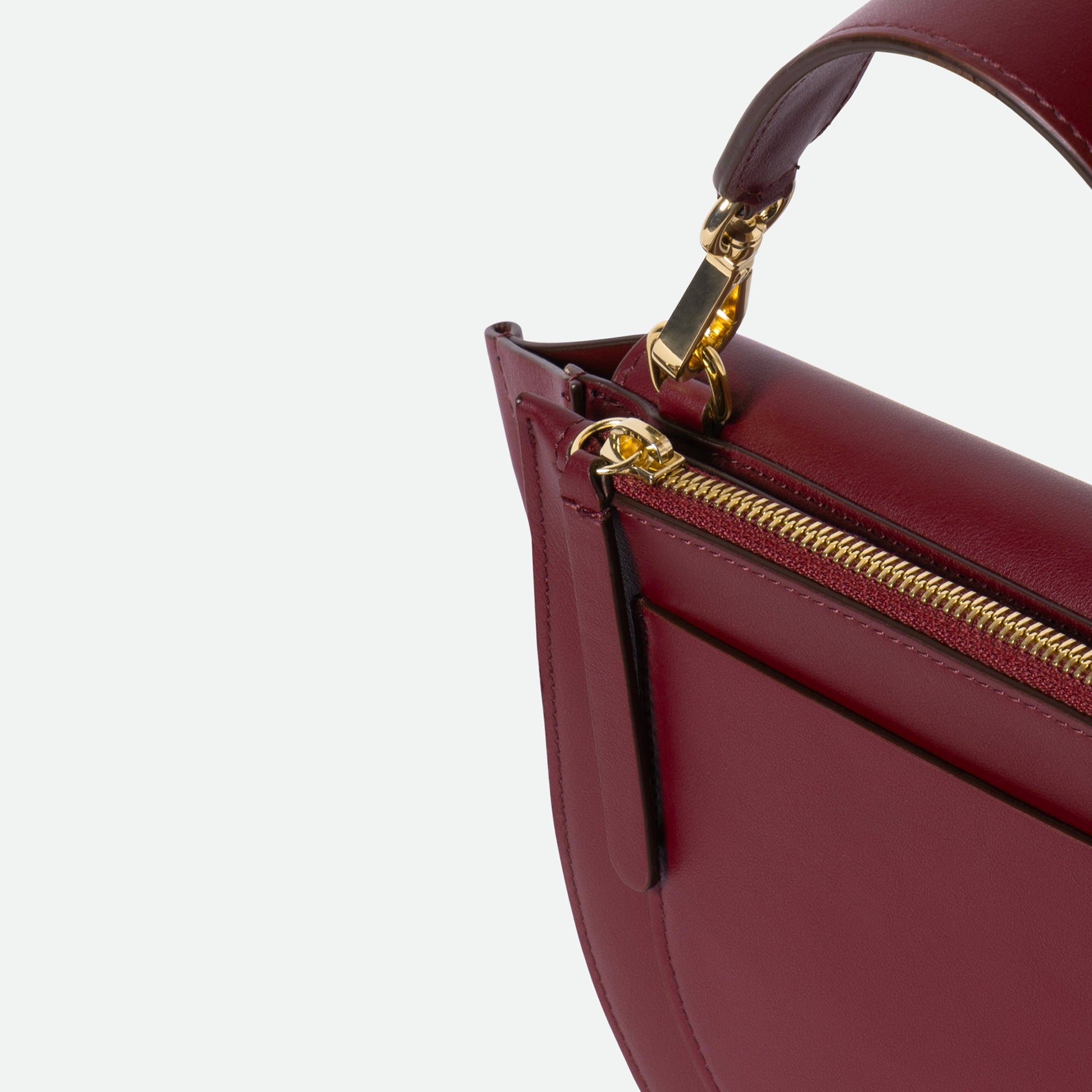 Wandler Hortensia Bag Mini in the color Acai, made from Italian calf leather with golden hardware, rounded silhouette and top handle, close up detailing the zipper and top handle.