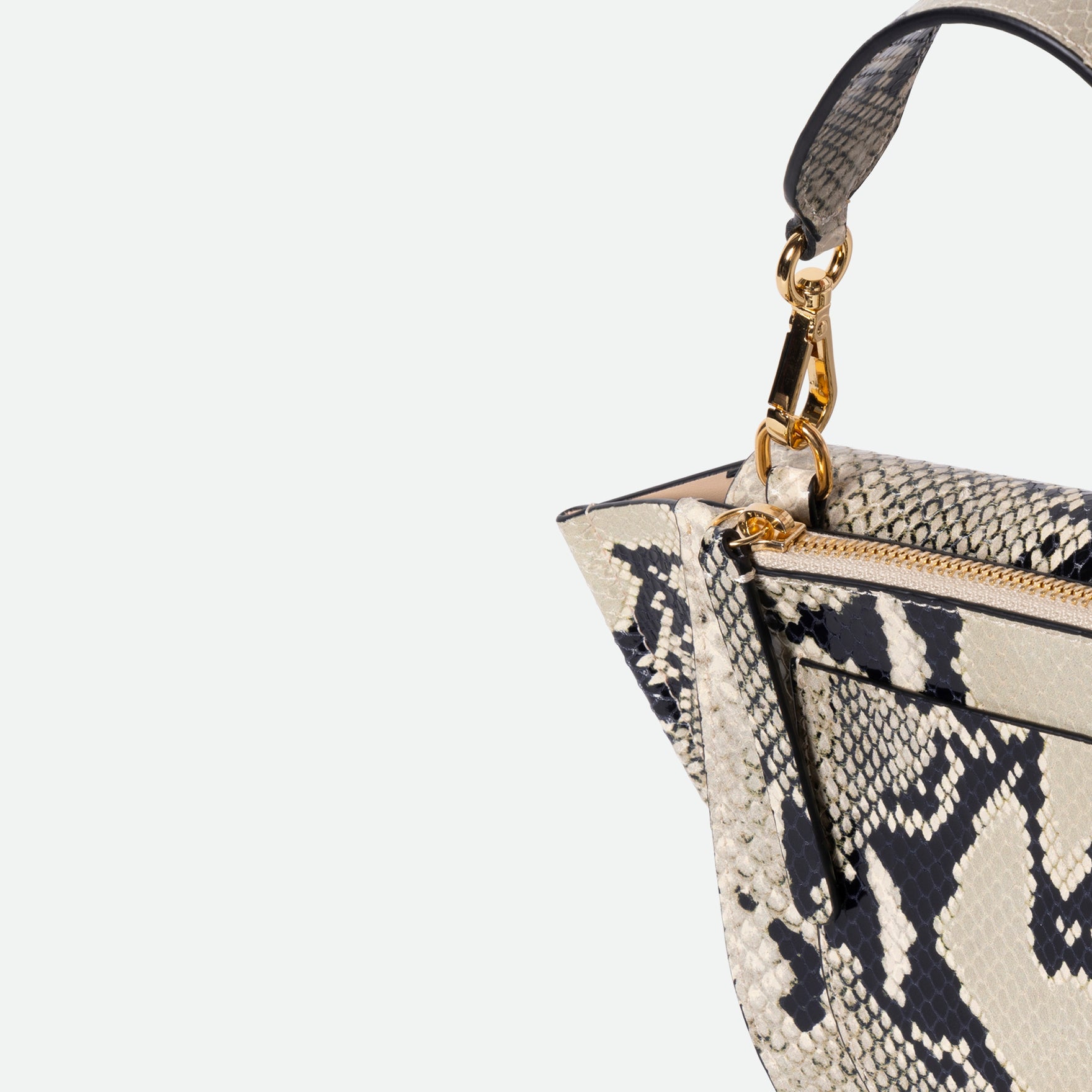 Wandler Hortensia Bag Mini in the color Black / White Python, Italian calf leather with golden hardware, rounded silhouette and top handle, detail shot featuring a close up of the zipper and top handle. 