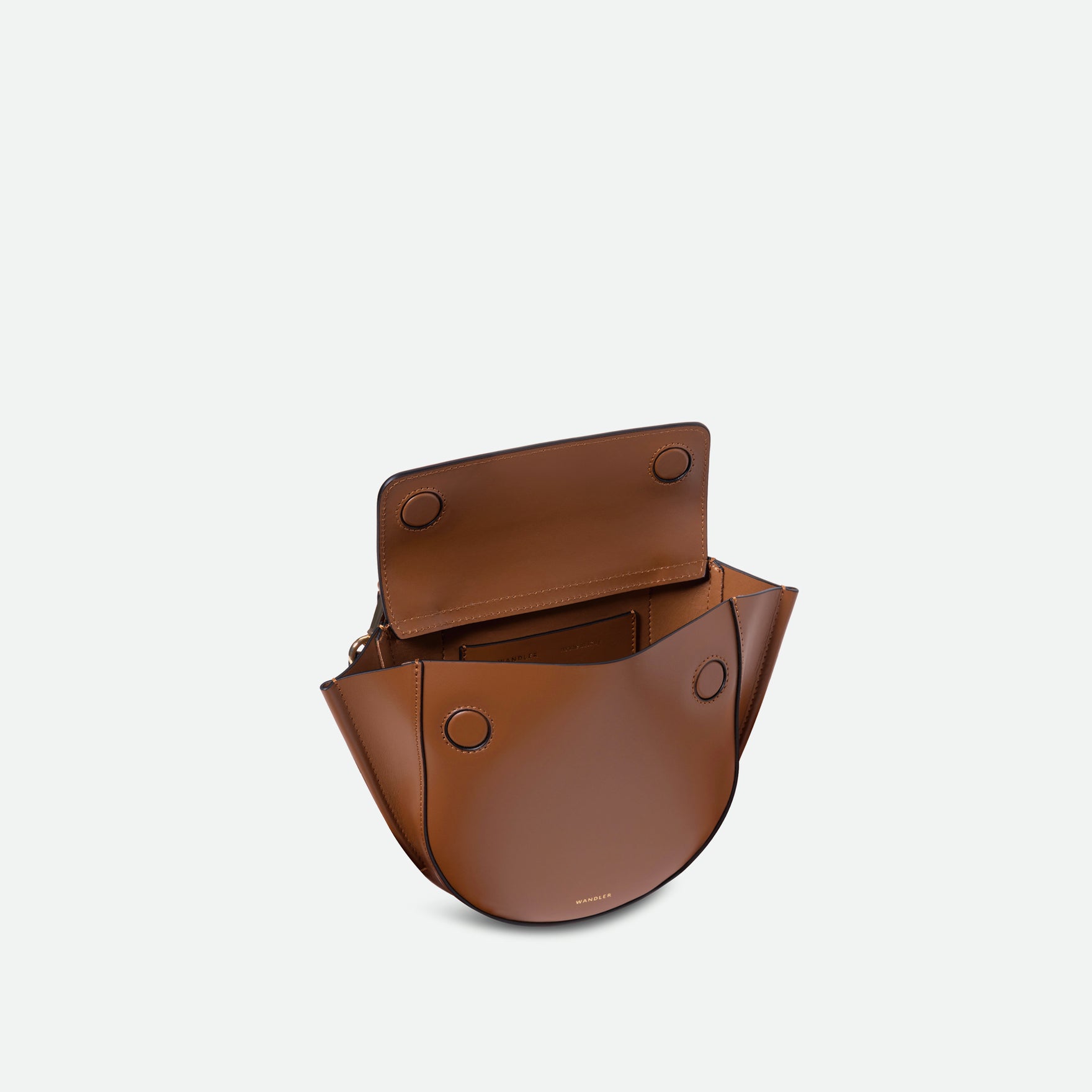 Wandler Hortensia Bag Mini in the color Saddle, brown, Italian calf leather with golden hardware, rounded silhouette and top handle. The bag is pictured from the front with the flap open, giving a slight view of the inside of the bag.