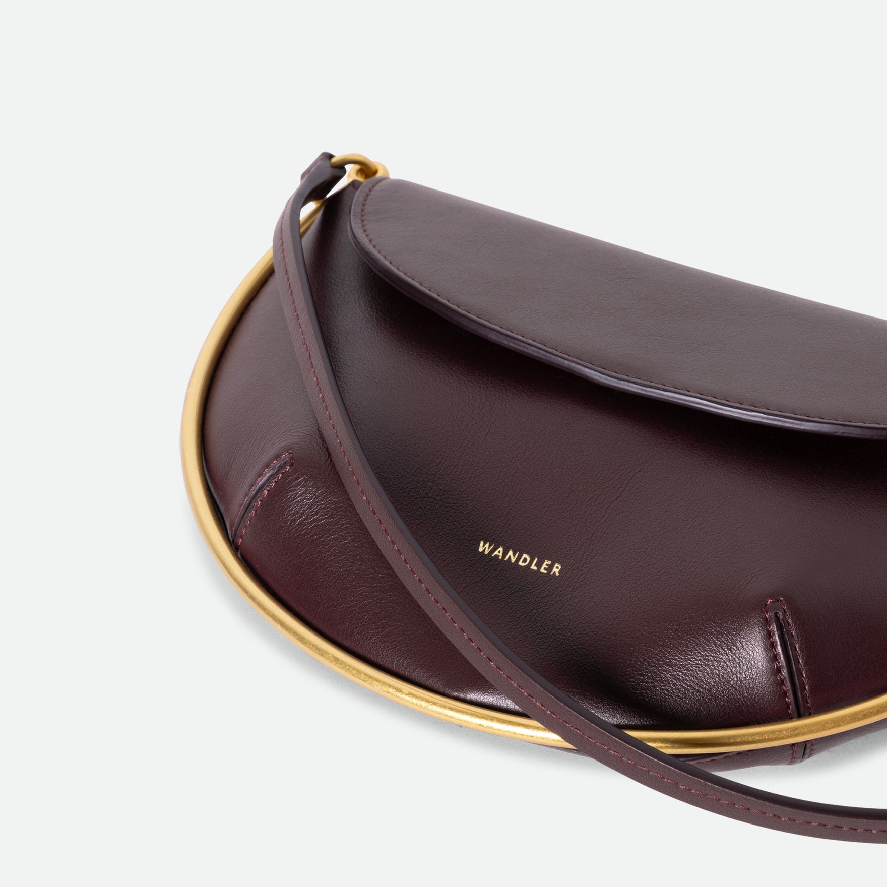 Wandler Kate Mini Crossbody in the color Grape, made from Italian calf leather with golden hardware and adjustable strap, close up detailing the logo and golden halo detail.