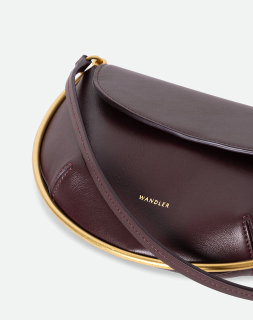 Wandler Kate Mini Crossbody in the color Grape, made from Italian calf leather with golden hardware and adjustable strap, close up detailing the logo and golden halo detail.