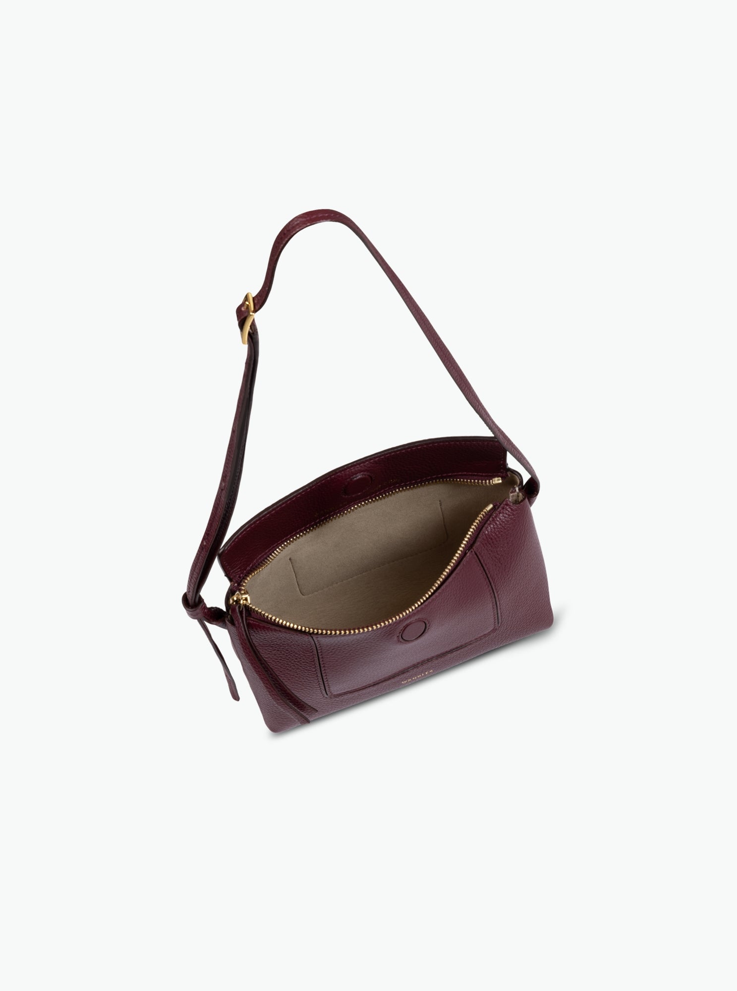 Wandler Penelope Slouch Mini in the color Acai, made from  Italian calf leather with golden hardware and slim adjustable strap, pictured with the bag being open allowing for a glimpse into the inside.