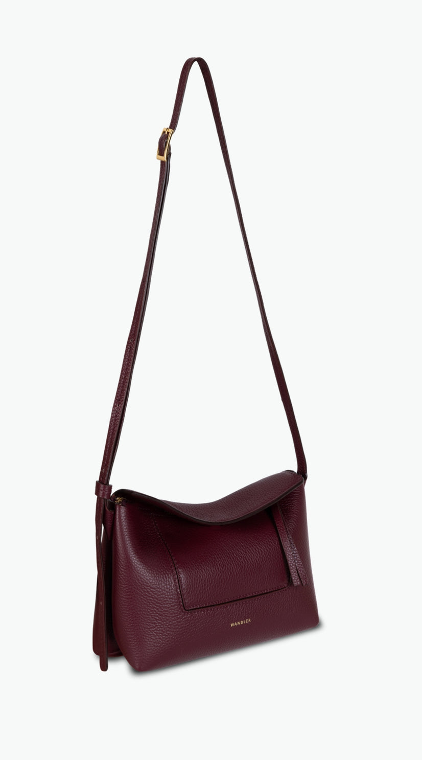 Wandler Penelope Slouch Mini in the color Acai, made from  Italian calf leather with golden hardware and slim adjustable strap, pictured with the straps suspended into the air.