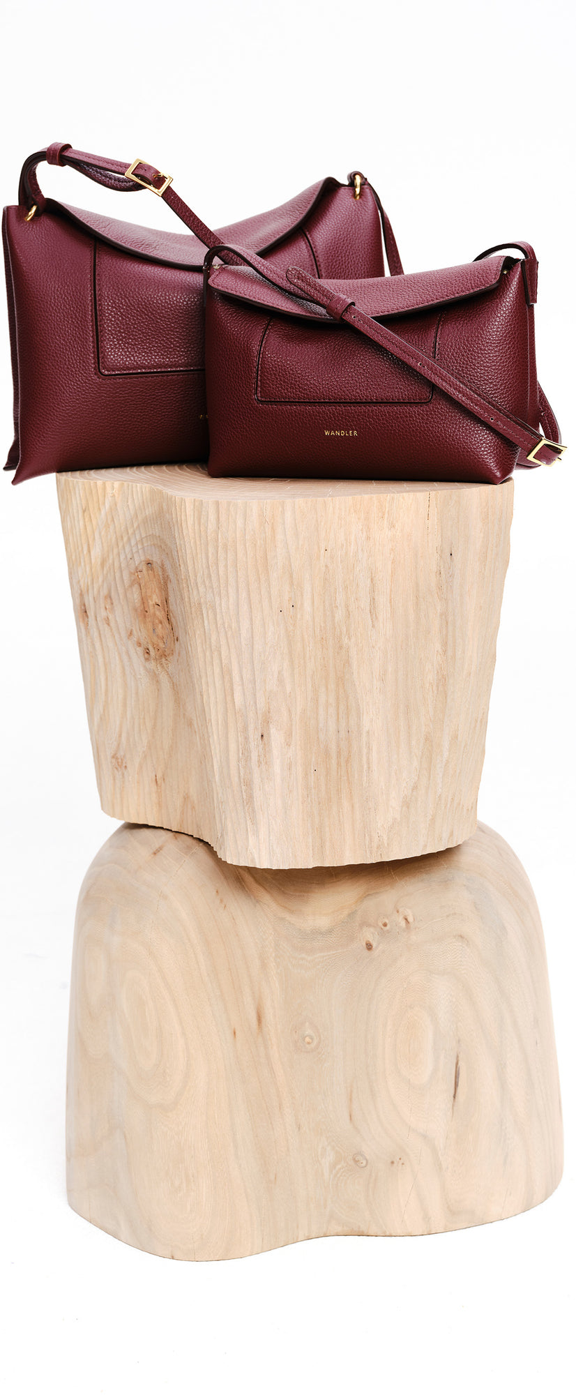 Wandler Penelope Slouch Mini in the color Acai, made from  Italian calf leather with golden hardware and slim adjustable strap, pictured next to the Penelope Slouch Bag.