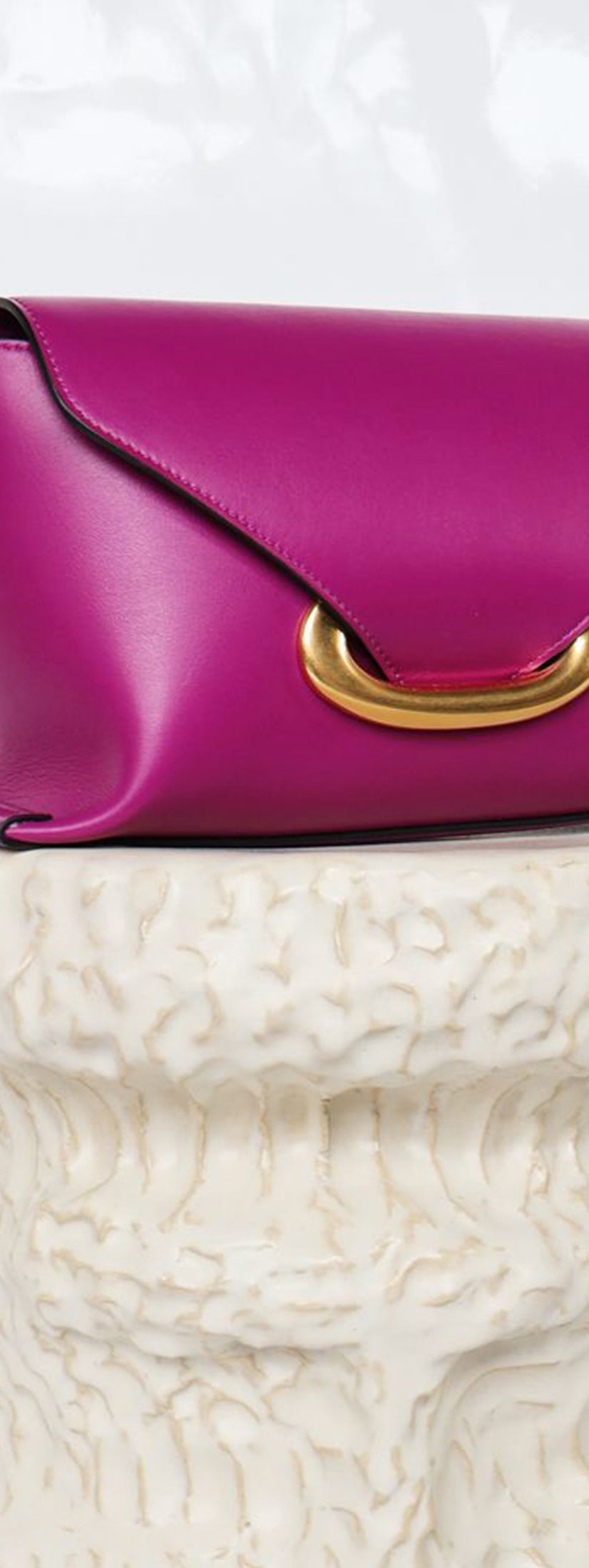 Wandler Veneto Shoulder Bag Small in the color Cobra, made from Italian calf leather with oversized golden clasp hardware, structured silhouette, pictured on pillar.