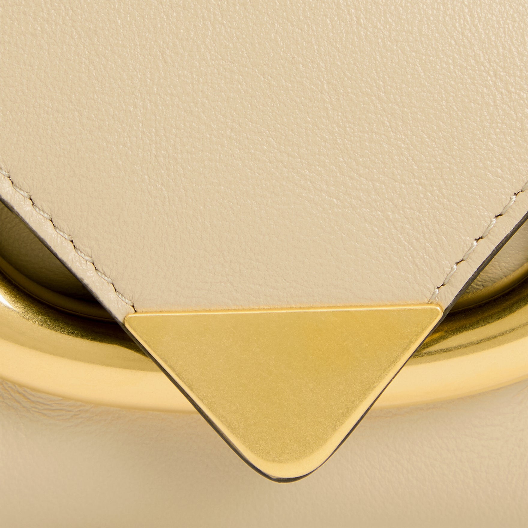 Wandler Veneto Shoulder Bag in the color Linen, beige, Italian calf leather with oversized golden clasp hardware and structured silhouette, close up detailing the clasp and leather.